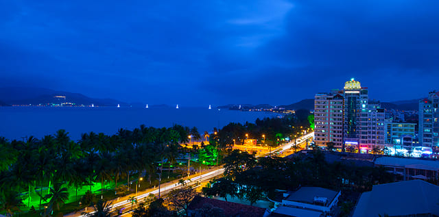 Hình ảnh bờ biển về đêm với ánh đèn lung linh